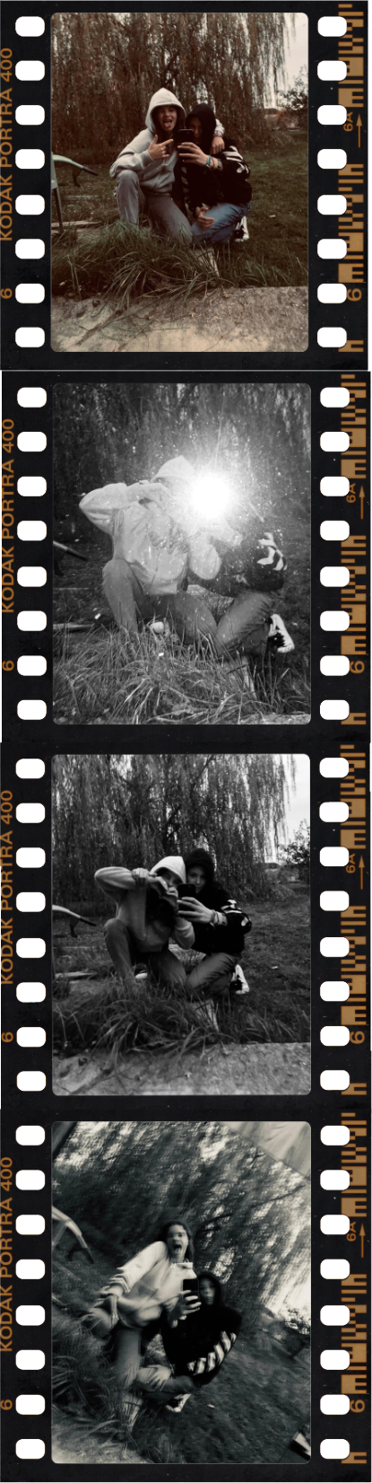 A strip of four black-and-white frames on Kodak Portra 400 film: two people mucking around on the grass under a willow tree, one frame washed out by the flash