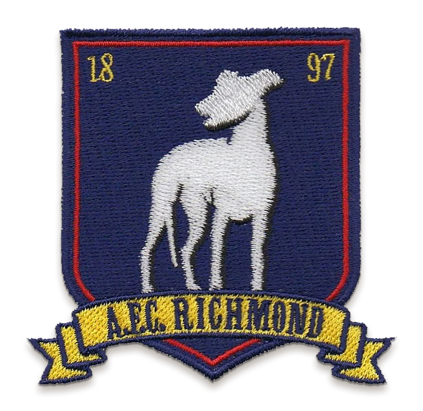 An embroidered AFC Richmond crest patch from Ted Lasso: a white greyhound on a navy shield with 1897 either side and a gold A.F.C. RICHMOND ribbon